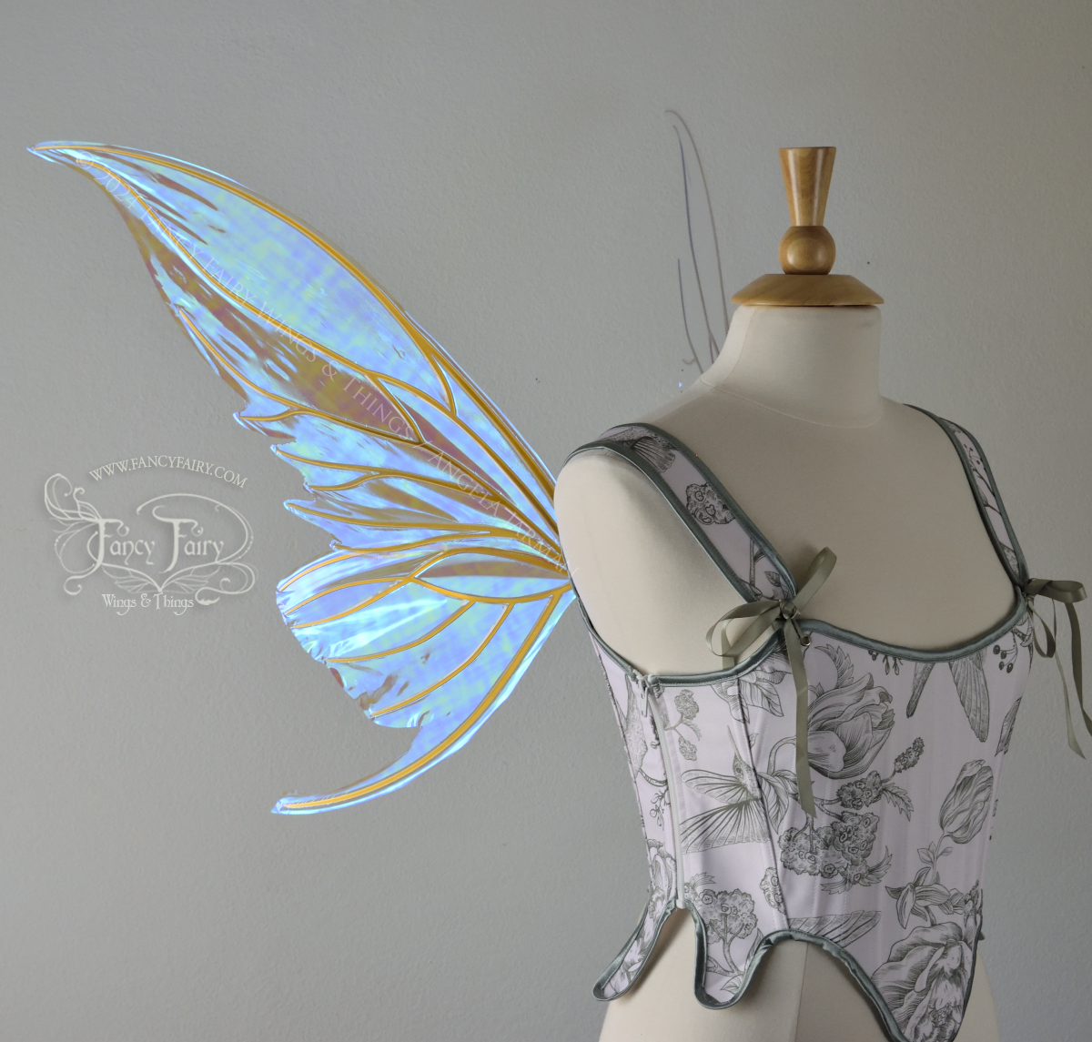 Large blue green iridescent fairy wings with gold veins worn with a white & sage green bodice on a dress form, left side view