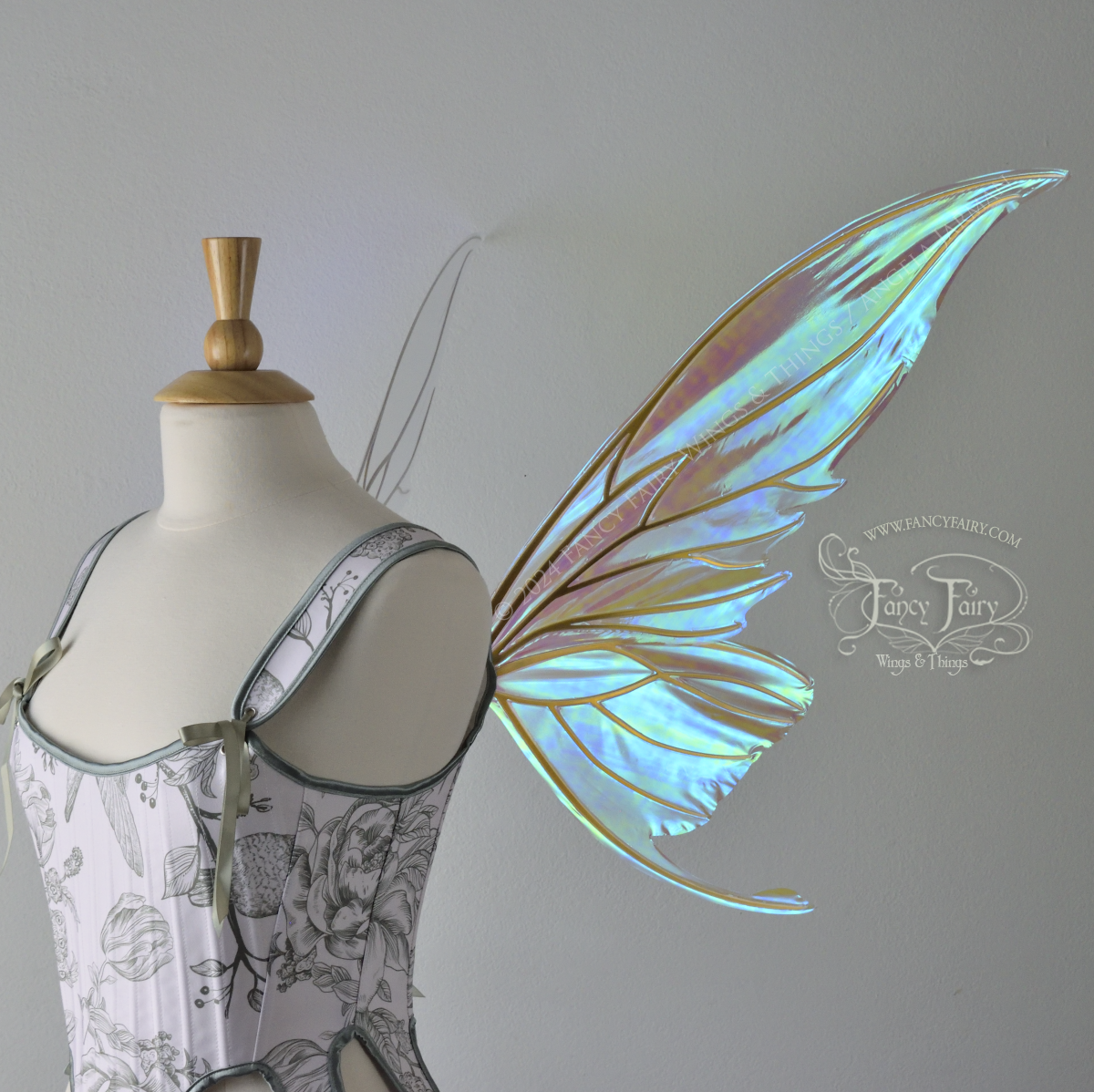 Large blue green iridescent fairy wings with gold veins worn with a white & sage green bodice on a dress form, right side view