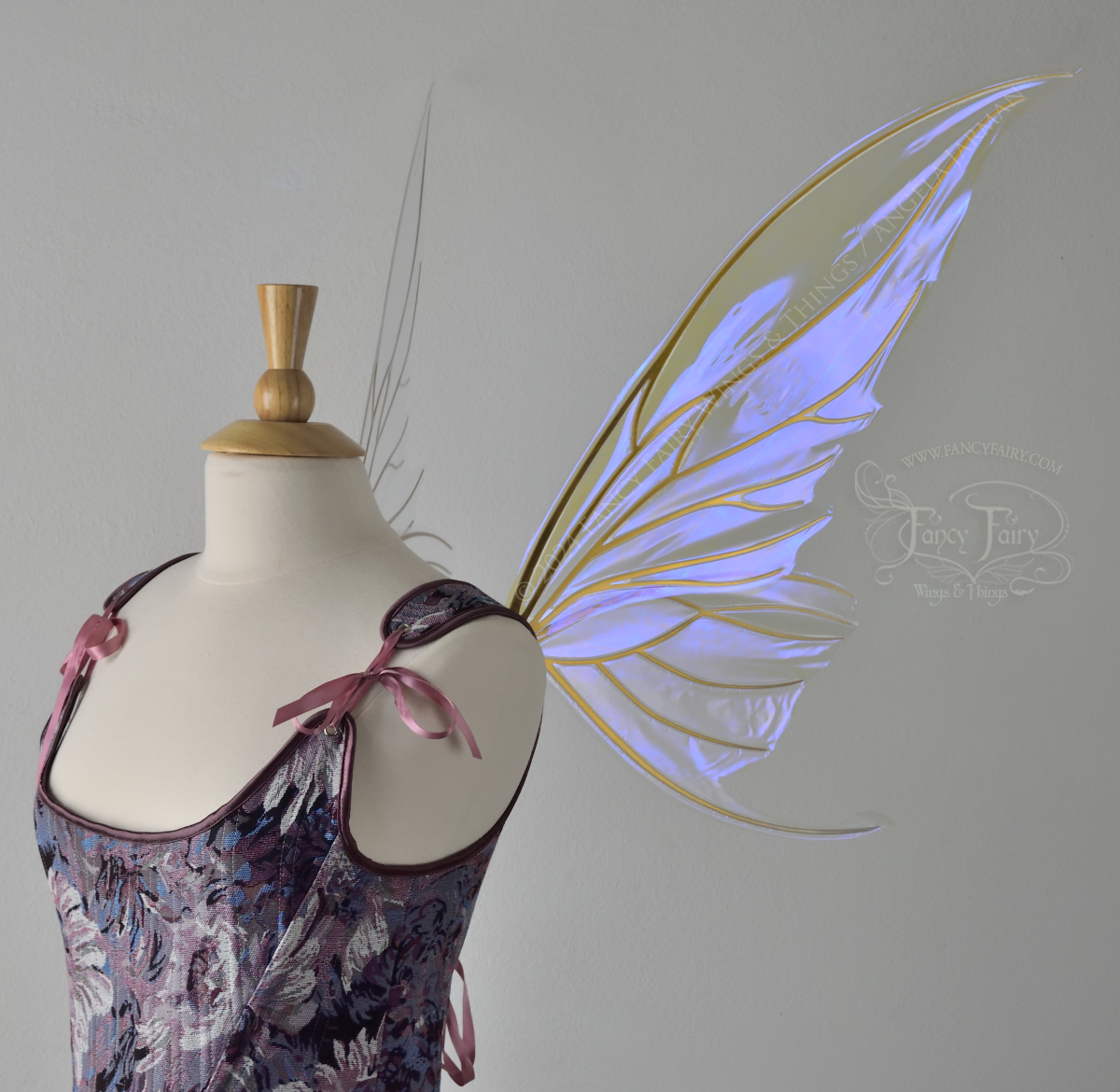 Large violet iridescent fairy wings with gold veins worn with a purple bodice on a dress form, Right side view