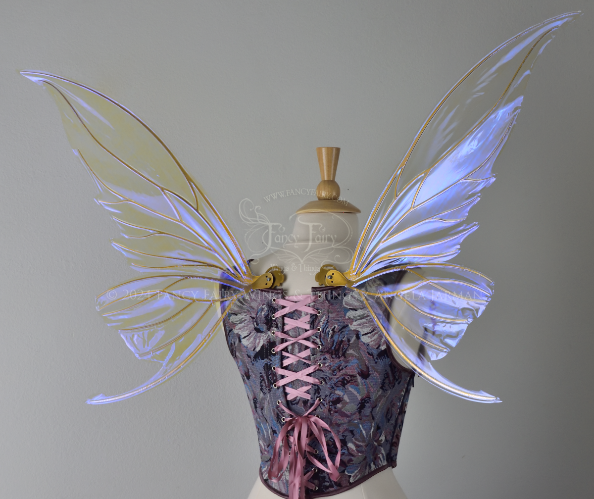 Large violet iridescent fairy wings with gold veins worn with a purple bodice on a dress form, back view