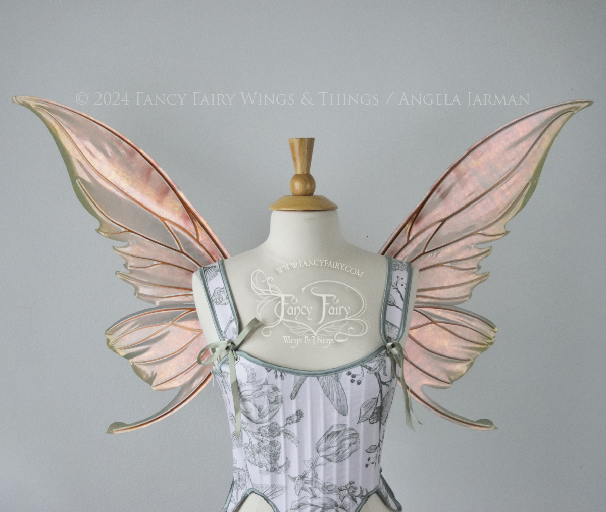 Large coppery iridescent fairy wings with brown and green accents, copper veins, worn with a white & sage green bodice on a dress form