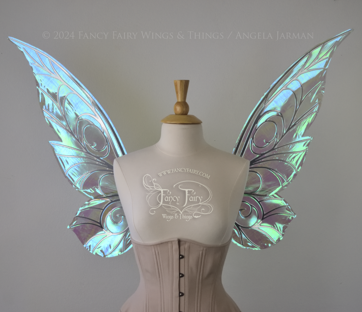 Front view of green iridescent Tinker Bell inspired fairy wings with swirly silver veins, displayed on a dress form