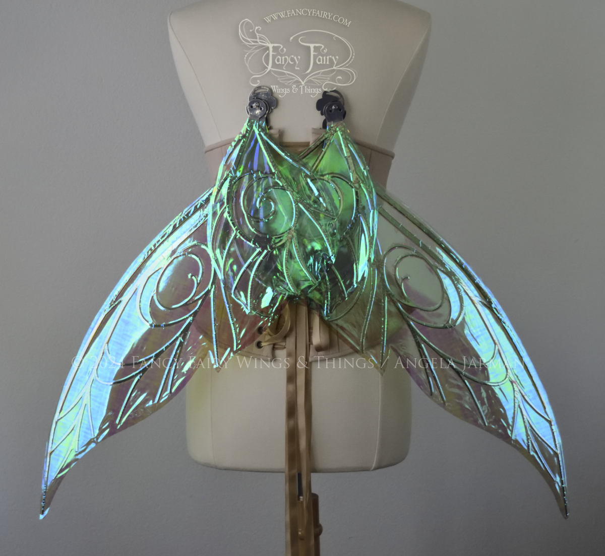 Back view of green iridescent Tinker Bell inspired fairy wings with swirly silver veins, displayed on a dress form in resting position