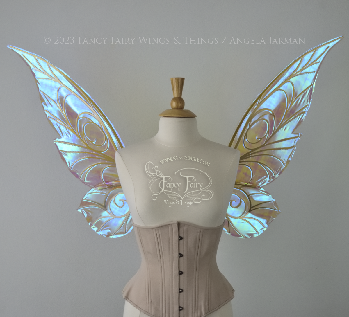 Front view of transparent blue iridescent Tinker Bell inspired fairy wings with swirly gold veins, displayed on a dress form