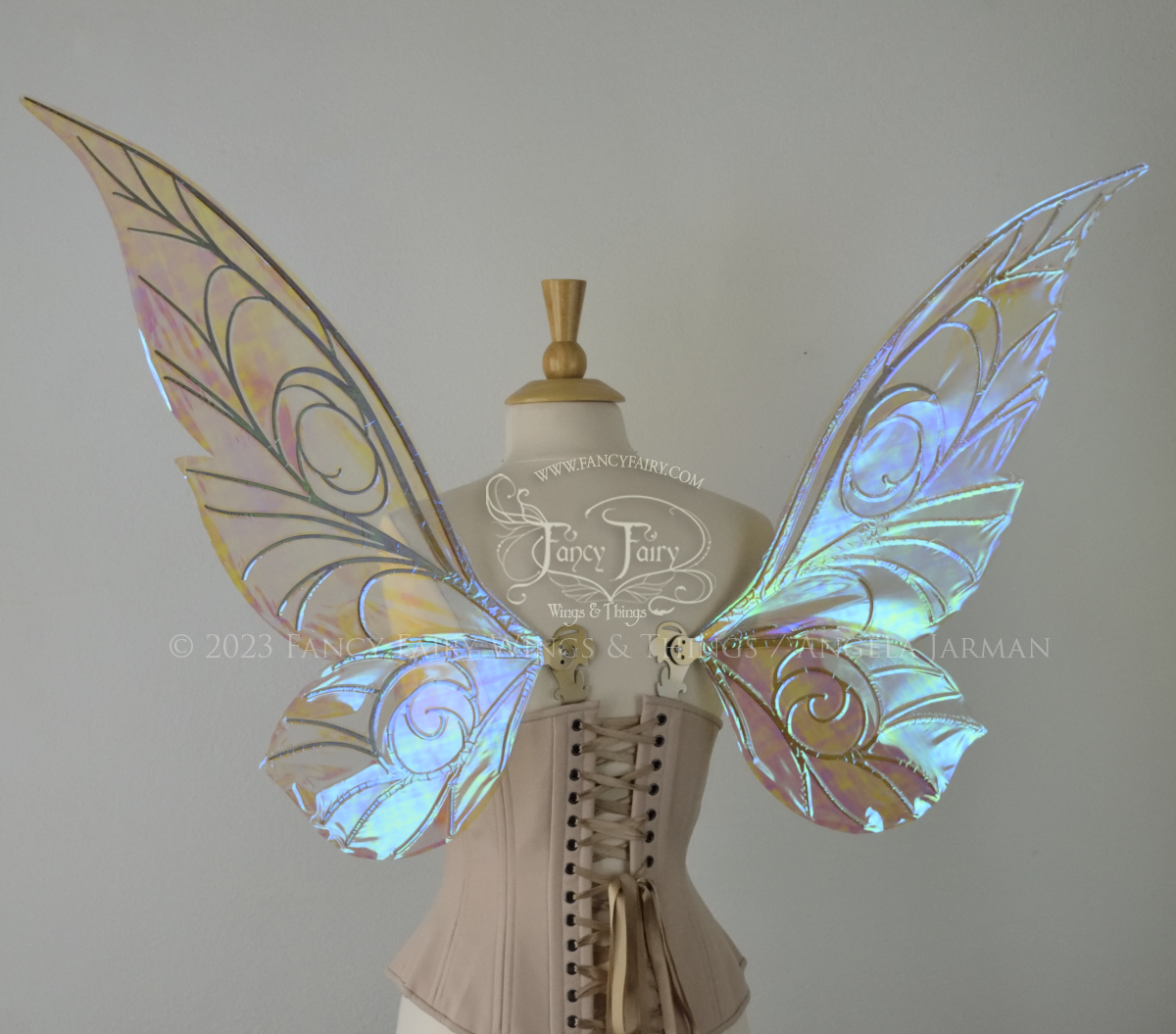 Back view of transparent blue iridescent Tinker Bell inspired fairy wings with swirly gold veins, displayed on a dress form