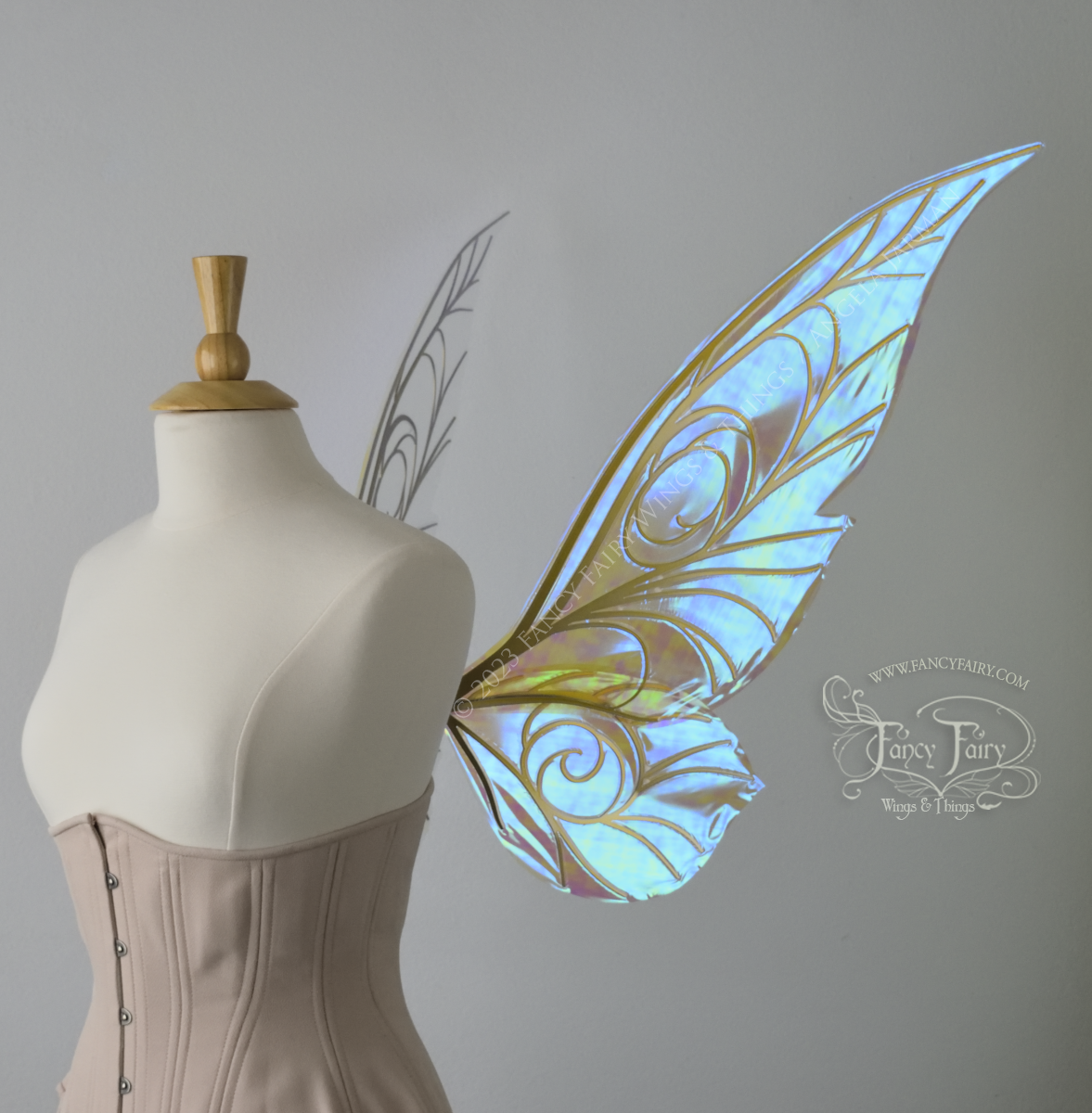 Right side view of transparent blue iridescent Tinker Bell inspired fairy wings with swirly gold veins, displayed on a dress form