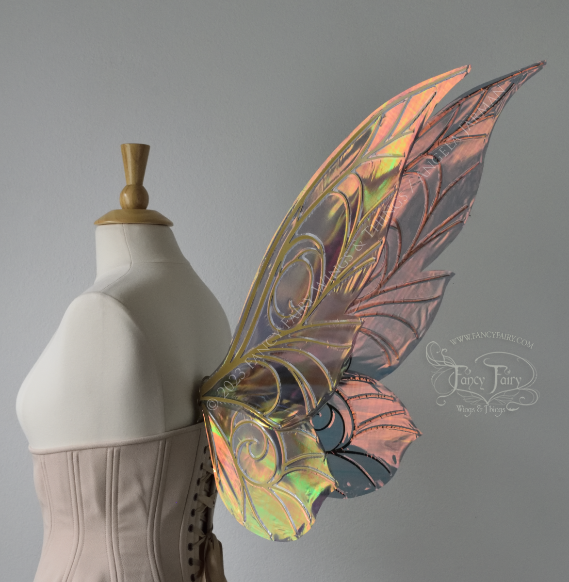 Back 3/4 view of black / orange iridescent Tinker Bell inspired fairy wings with swirly gold veins, displayed on a dress form