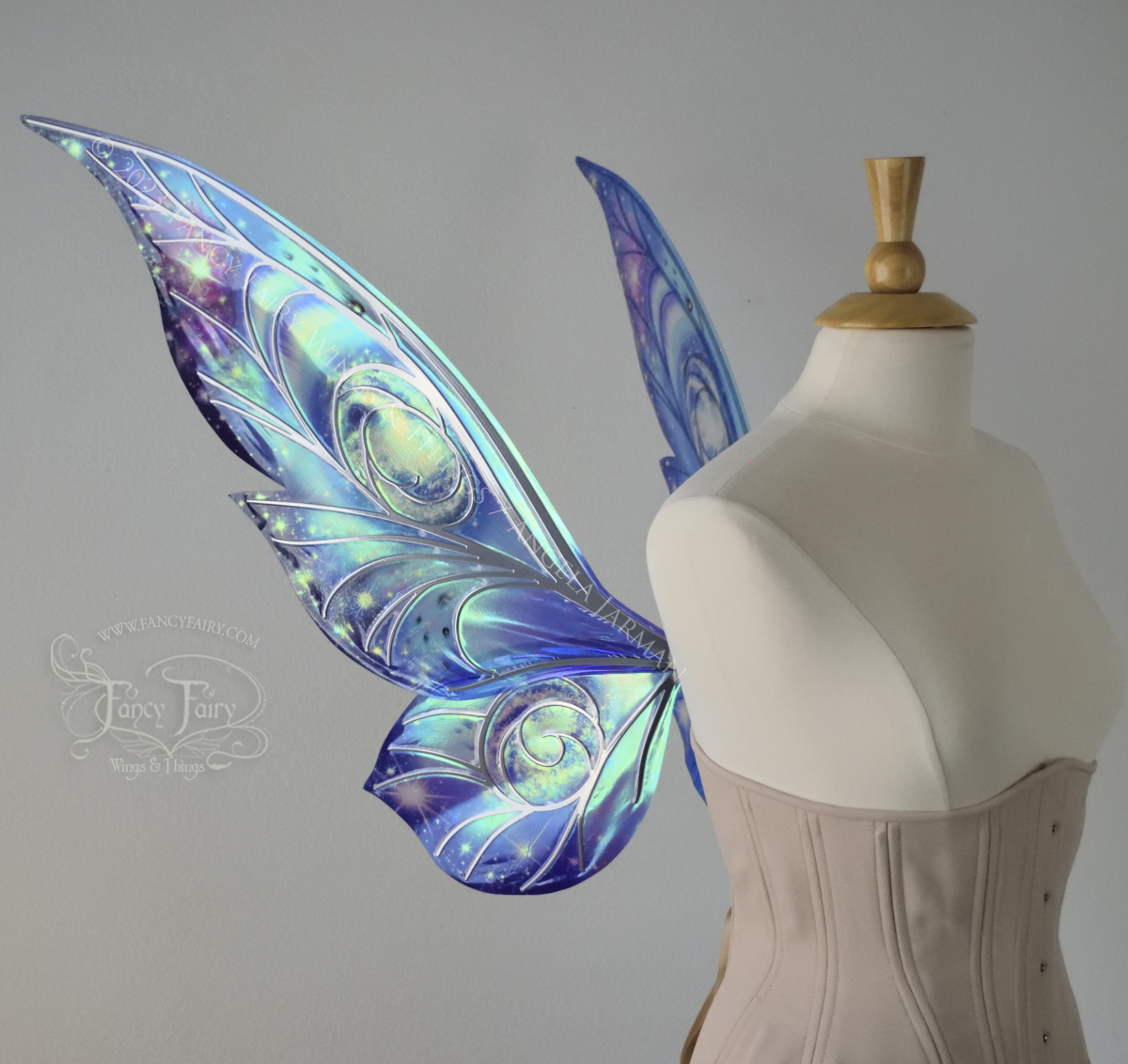 Left side view of celestial iridescent fairy wings with blue skies, fuchsia nebulas, auroras and stars, with silver veins, worn on a dress form 