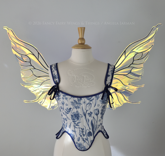 Transparent iridescent fairy wings with wavy tips and black veins, worn on a dress form, front view