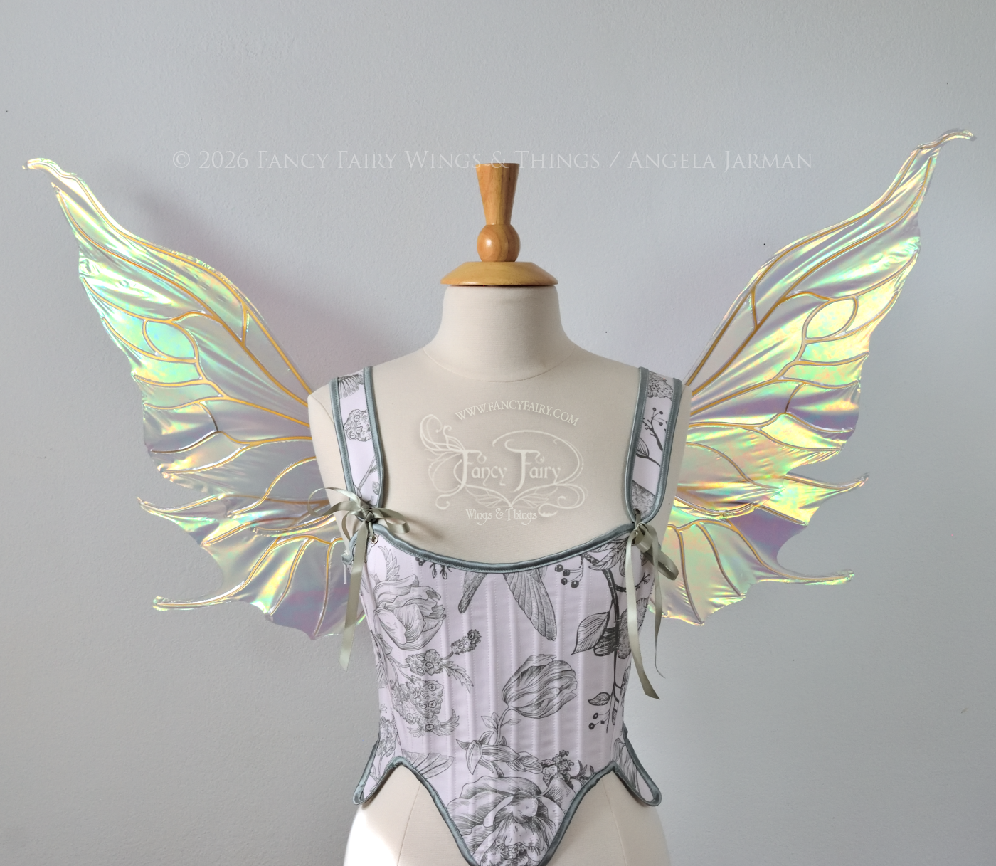 Sheer green iridescent fairy wings with wavy tips and gold veins, worn on a dress form, front view