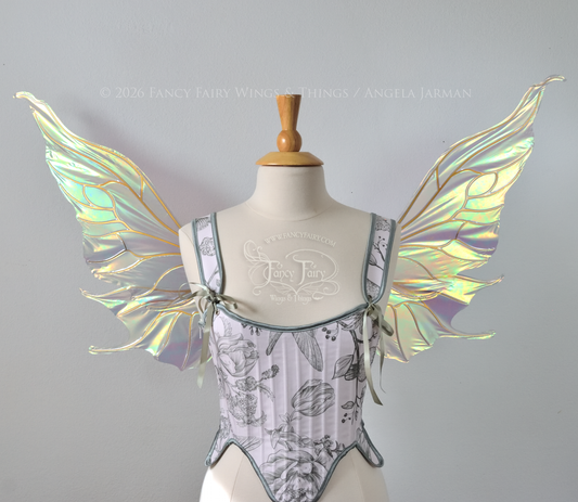 Sheer green iridescent fairy wings with wavy tips and gold veins, worn on a dress form, front view