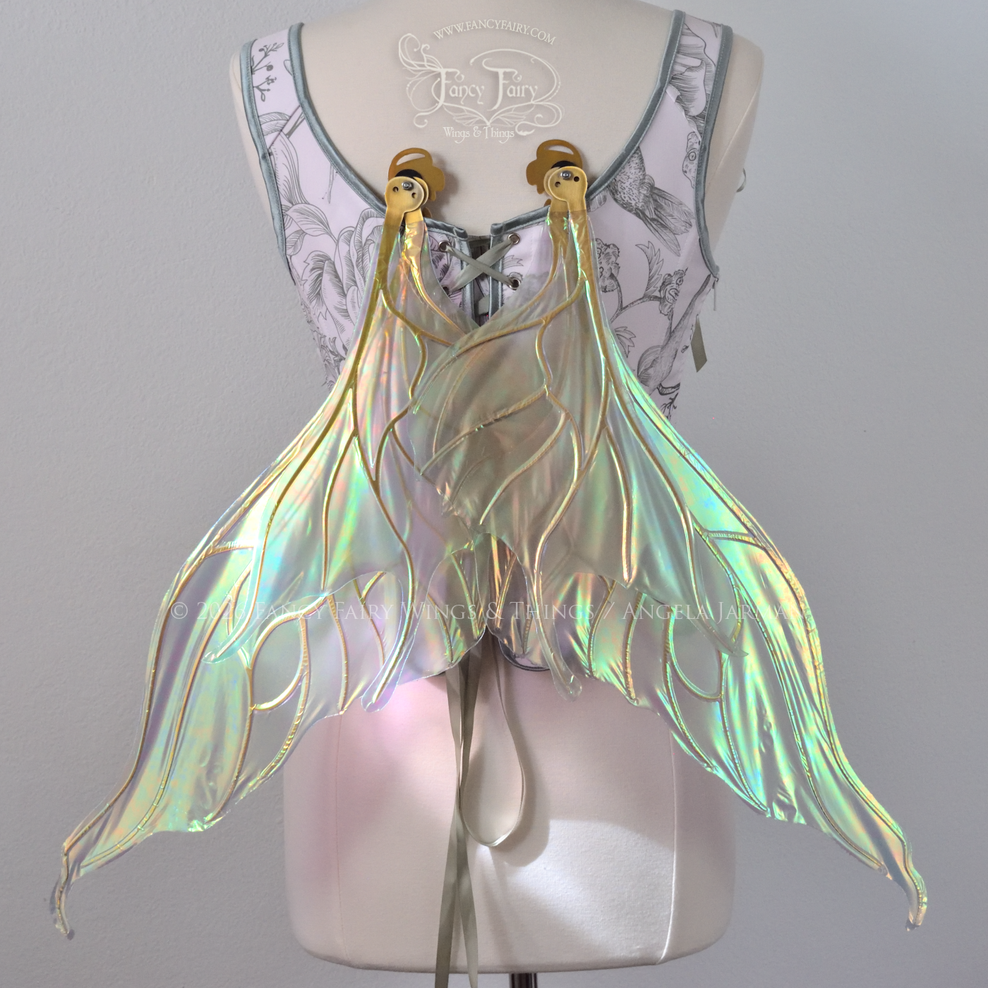 Sheer green iridescent fairy wings with wavy tips and gold veins, worn on a dress form, back view in resting position