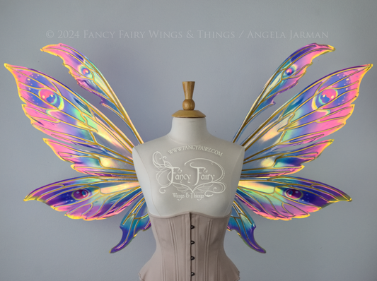 Extra large rainbow iridescent fairy wings with antennae and gold veins, front view, worn on a dress form