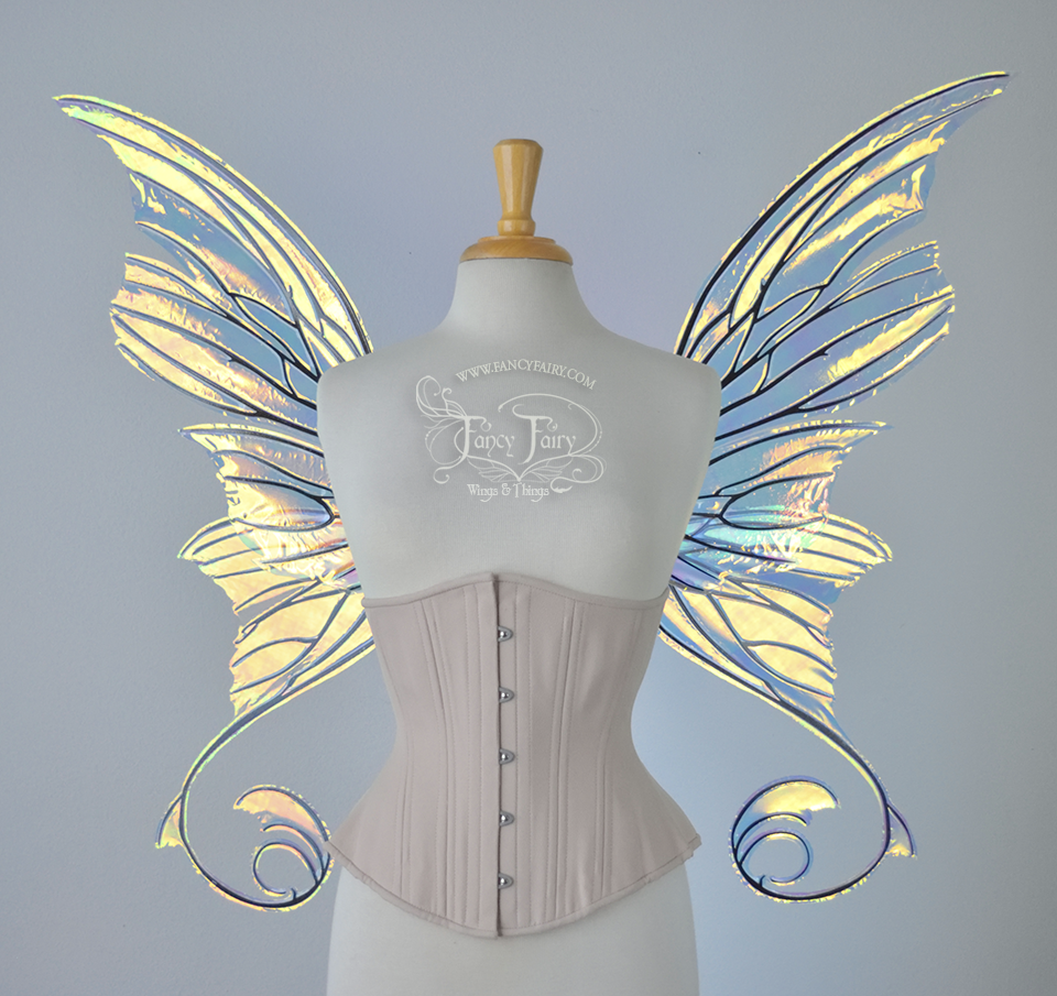 Front view of an ivory dress form wearing an alabaster underbust corset and large fairy wings with lots of intricate veins, some have 'thorns'. The upper panels curve slightly downwards along the top edge with pointy tips, the bottom panels have tails that curve inward toward the body. They are transparent and clear Diamond Fire iridescent, with black veins.