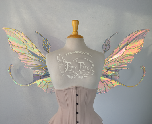 Front view of an ivory dress form wearing an alabaster underbust corset & large orange/green  iridescent fairy wings with elongated upper panels & antennae with bottom panels that have a tail curving upwards, gold veins