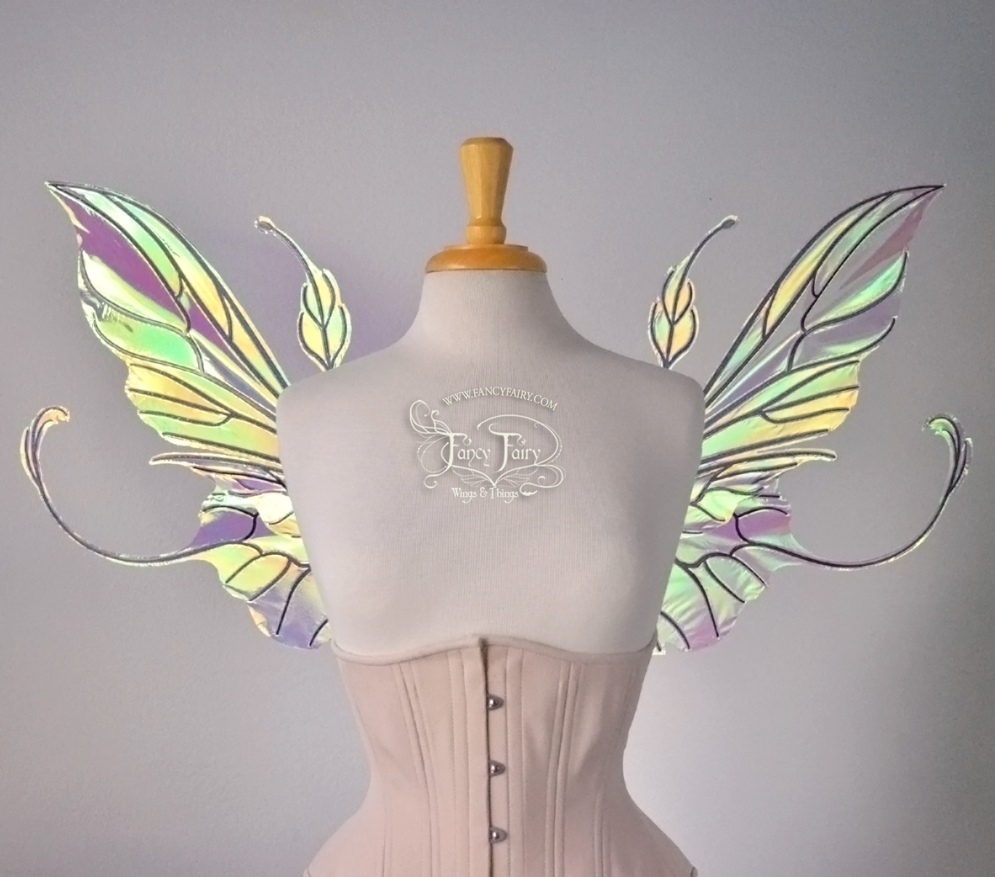 Front view of an ivory dress form wearing an alabaster underbust corset & large clear iridescent fairy wings with elongated upper panels & antennae with bottom panels that have a tail curving upwards, black veins