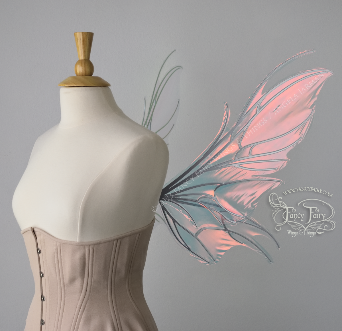 Right side view of iridescent pink / orange fairy wings with spikey silver veins, worn by a dress form