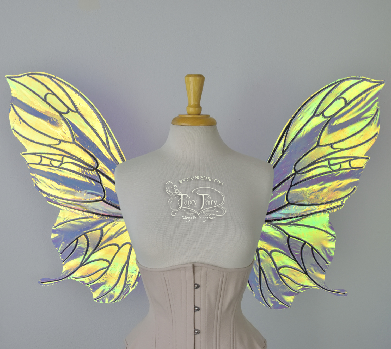 Front view of an ivory dress form wearing an alabaster underbust corset & large iridescent fairy wings with a sort of butterfly shape. The veins are black