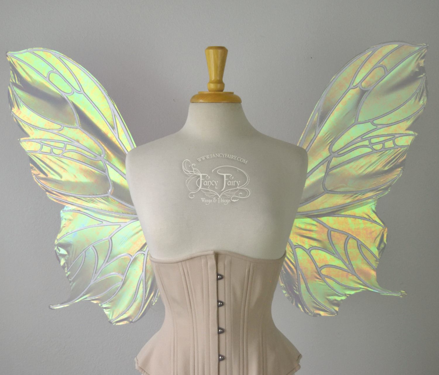 Front view of an ivory dress form wearing an alabaster underbust corset & large iridescent fairy wings with a sort of butterfly shape. The veins are white