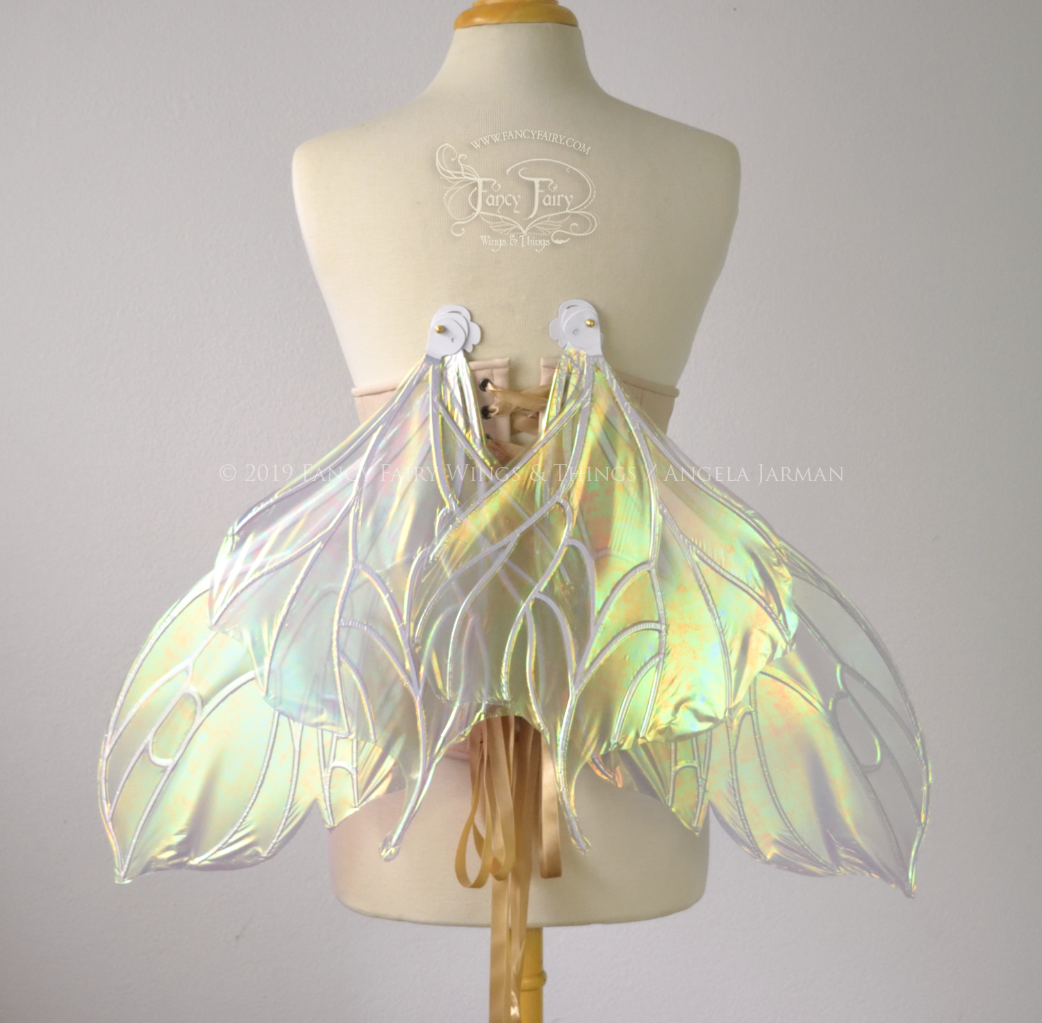 Back view of an ivory dress form wearing an alabaster underbust corset & large iridescent fairy wings with a sort of butterfly shape in resting  position. The veins are white