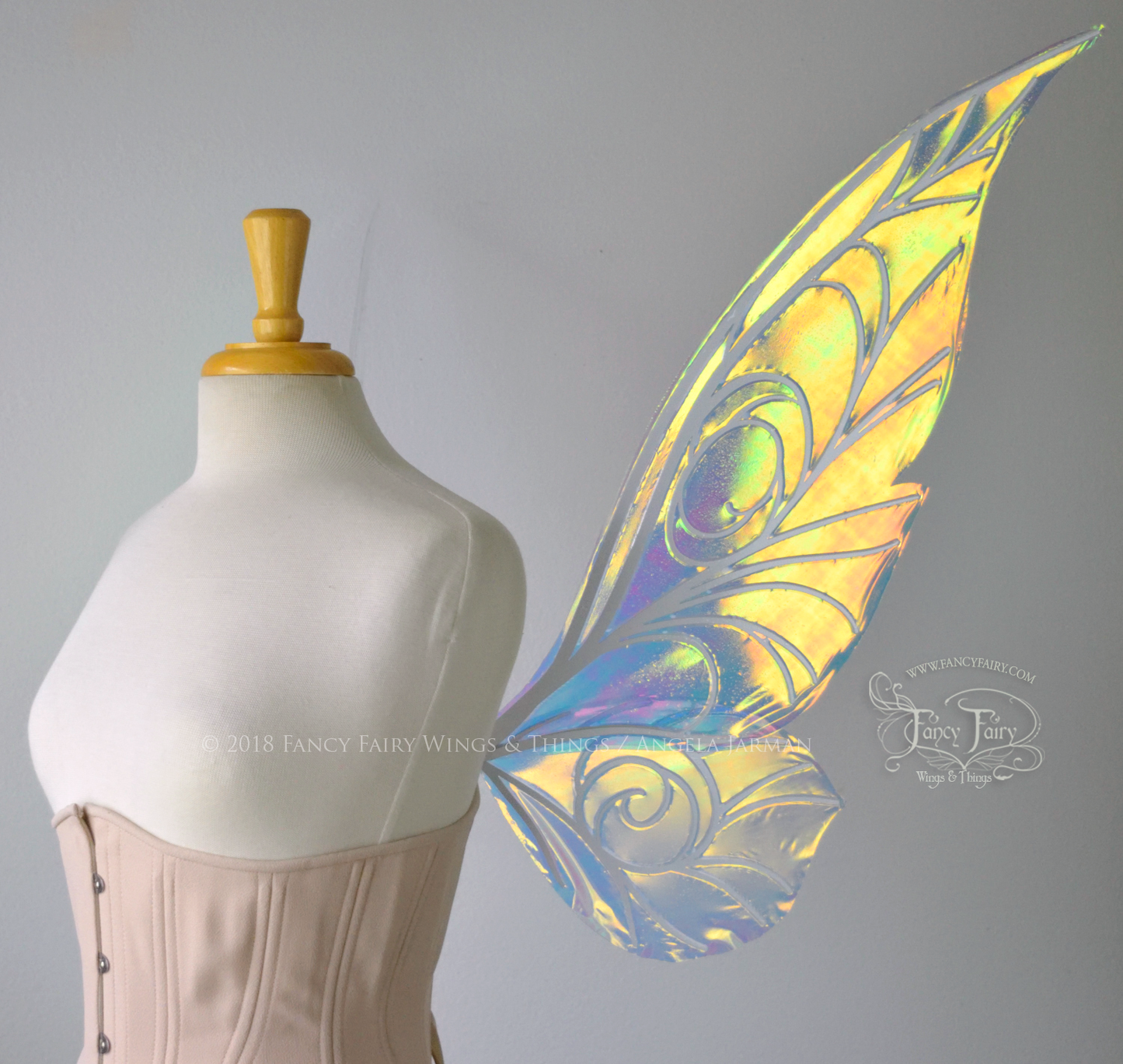 Right side view of transparent green/yellow/orange iridescent Tinker Bell inspired fairy wings with swirly white veins, displayed on a dress form