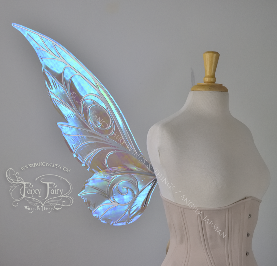 Left side view of transparent blue iridescent Tinker Bell inspired fairy wings with swirly white veins, displayed on a dress form