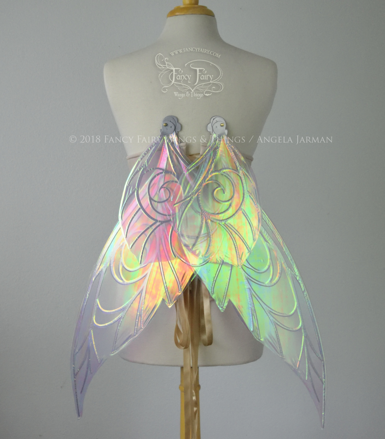 Back view of transparent green/yellow/orange iridescent Tinker Bell inspired fairy wings with swirly white veins, displayed on a dress form in resting position